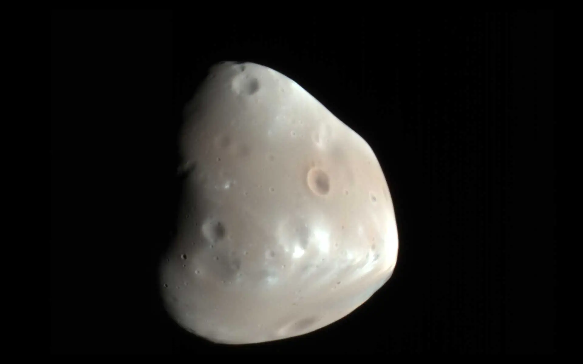 Image of Deimos showing a small, irregularly shaped moon against space.