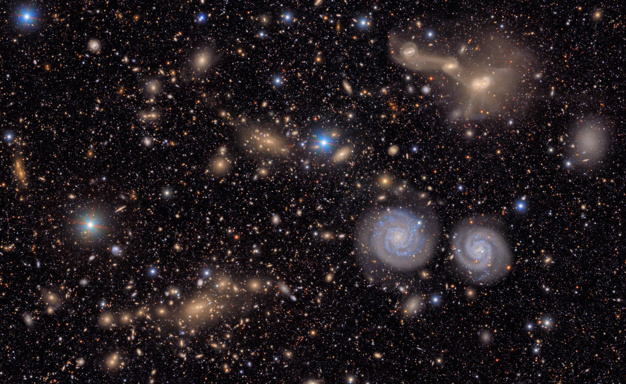 Deep Rubin Observatory field showing thousands of galaxies and stars, including many small spiral and elliptical galaxies at different apparent sizes and colors.